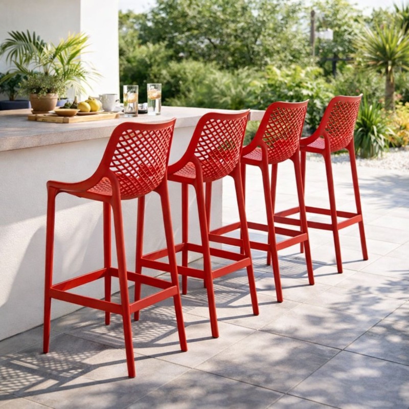 Lot de 4 tabourets de jardin BROZER rouges en plastique, installés autour d’un bar extérieur moderne